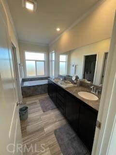 full bath featuring crown molding, double vanity, a sink, and wood finished floors