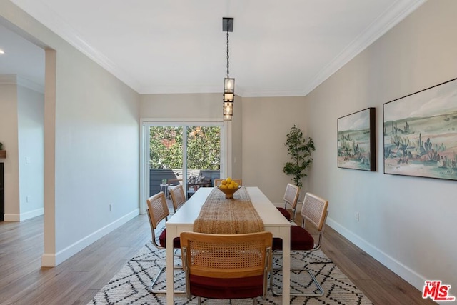 dining area with hardwood / wood-style flooring and crown molding