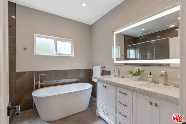 bathroom with tile patterned floors, vanity, tile walls, and independent shower and bath