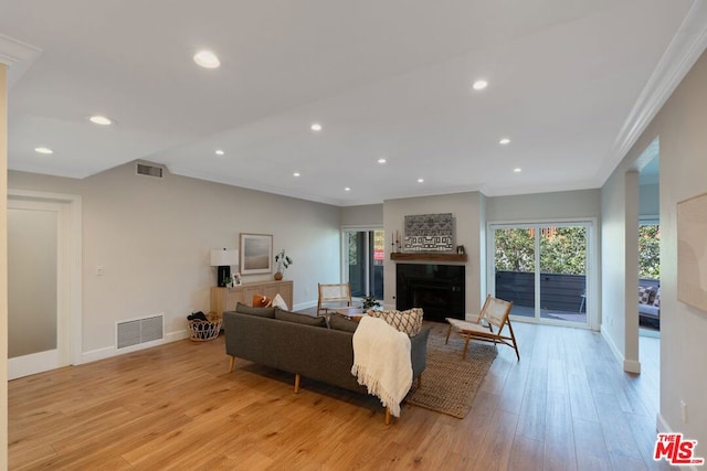 living room featuring light wood-type flooring and ornamental molding