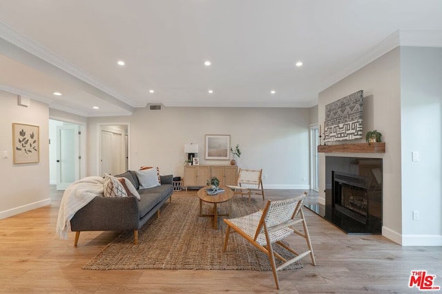 living room with crown molding and light hardwood / wood-style flooring