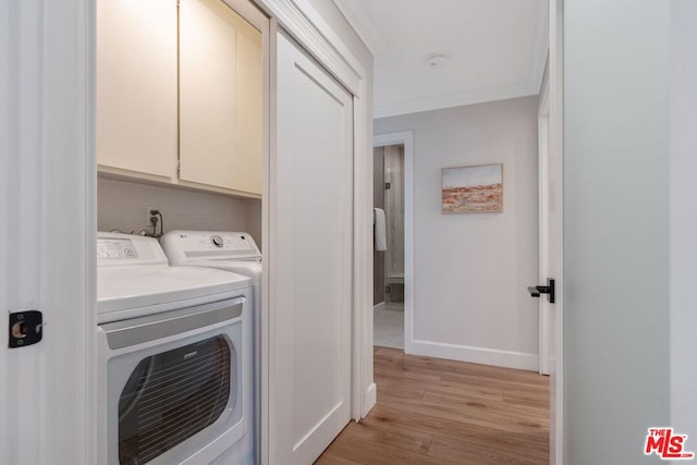 laundry room with washer and dryer, cabinets, ornamental molding, and light hardwood / wood-style flooring