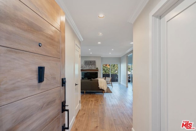 corridor featuring ornamental molding and light hardwood / wood-style flooring