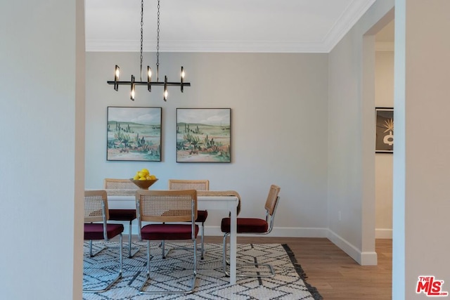 dining area featuring a chandelier, wood-type flooring, and crown molding