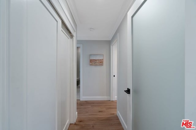 hall featuring crown molding and light hardwood / wood-style flooring