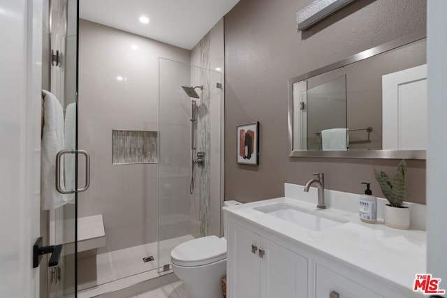 bathroom with tile patterned floors, vanity, toilet, and an enclosed shower