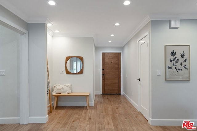 corridor with light hardwood / wood-style floors and crown molding