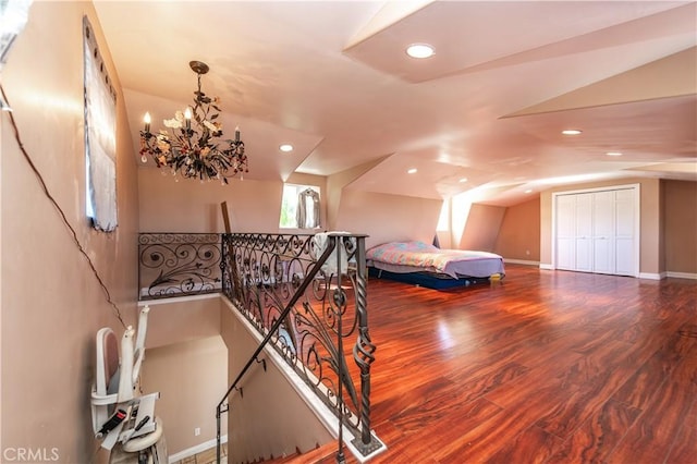 bedroom with a chandelier, hardwood / wood-style floors, and lofted ceiling