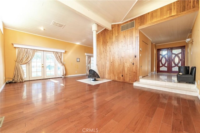 unfurnished living room with beam ceiling, french doors, and hardwood / wood-style floors