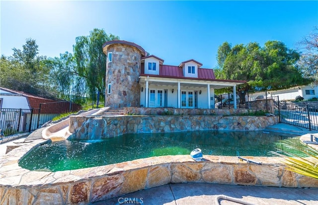 view of pool with pool water feature and french doors