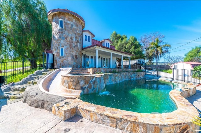 view of swimming pool with pool water feature, an outdoor structure, and an in ground hot tub