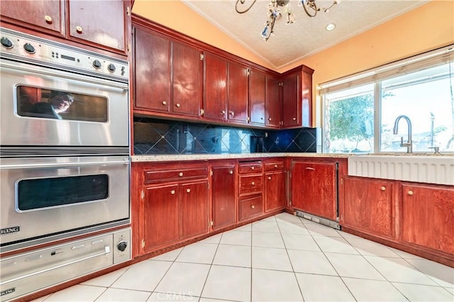 kitchen featuring decorative backsplash, stainless steel double oven, vaulted ceiling, sink, and light tile patterned flooring