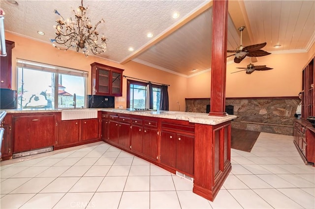 kitchen featuring light tile patterned floors, kitchen peninsula, sink, and a wealth of natural light