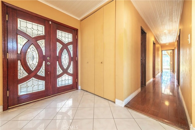 tiled entrance foyer featuring ornamental molding and wooden ceiling