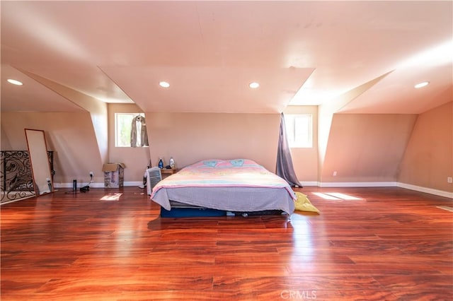 bedroom featuring wood-type flooring, multiple windows, and lofted ceiling