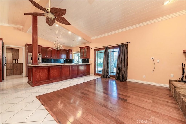 kitchen featuring kitchen peninsula, lofted ceiling, light tile patterned flooring, wood ceiling, and ceiling fan with notable chandelier