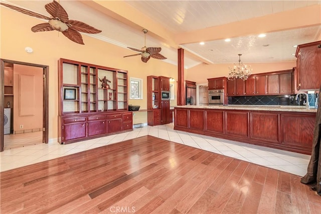 kitchen featuring kitchen peninsula, appliances with stainless steel finishes, lofted ceiling with beams, and light hardwood / wood-style flooring