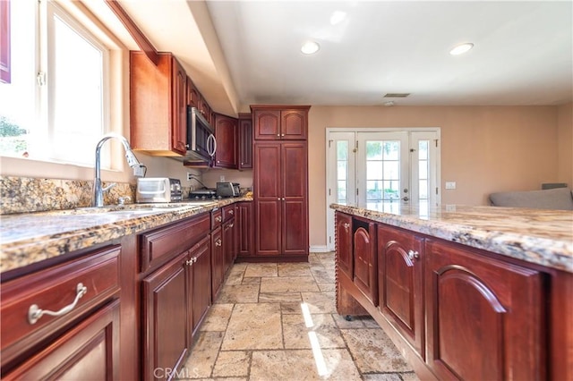 kitchen with light stone counters and sink