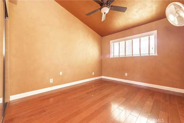 spare room with ceiling fan, wood-type flooring, and vaulted ceiling