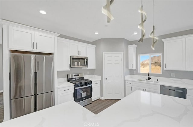 kitchen with stainless steel appliances, dark wood-type flooring, sink, decorative light fixtures, and white cabinets