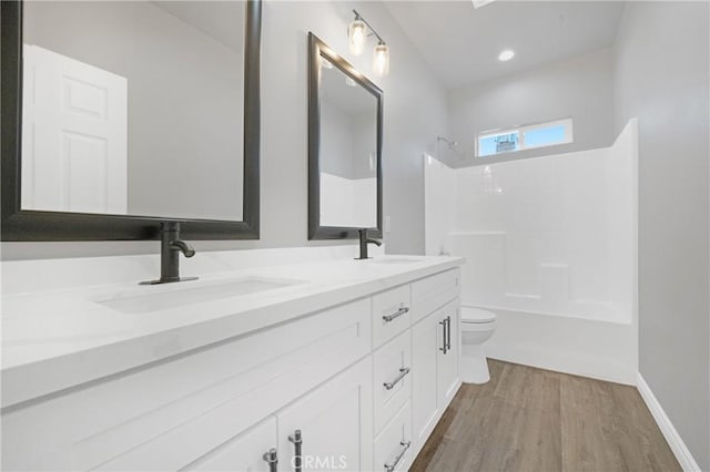 full bathroom with shower / bathing tub combination, vanity, hardwood / wood-style flooring, and toilet