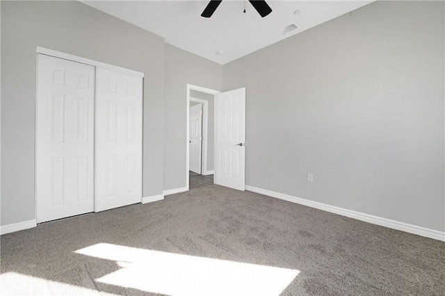 unfurnished bedroom with ceiling fan, a closet, and dark colored carpet