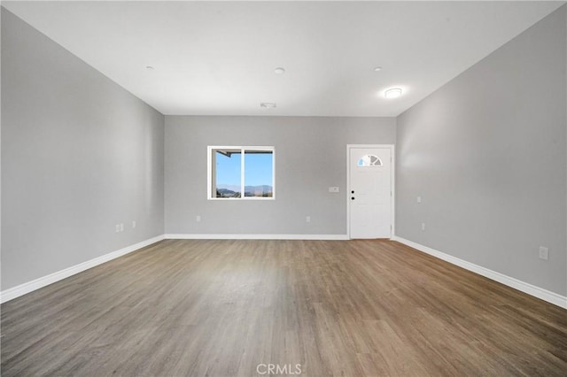 unfurnished room with hardwood / wood-style flooring