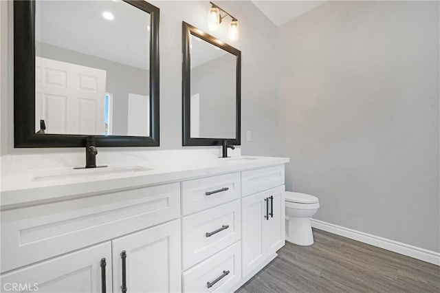 bathroom with hardwood / wood-style floors, vanity, and toilet