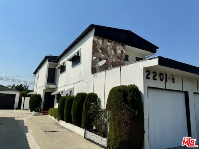 view of property exterior with a garage and an outdoor structure