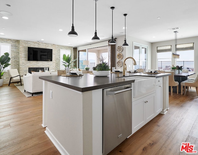 kitchen with a healthy amount of sunlight, dishwasher, white cabinets, and pendant lighting