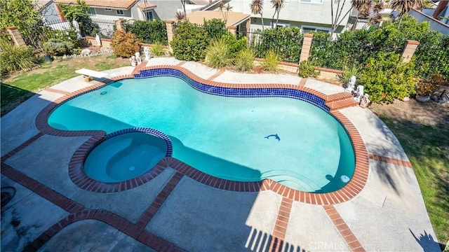 view of swimming pool with an in ground hot tub and a diving board