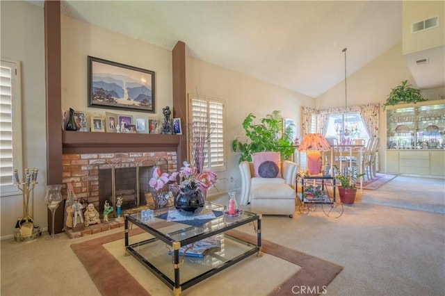 carpeted living room with high vaulted ceiling, a chandelier, and a brick fireplace