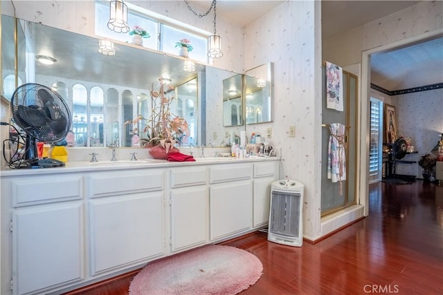 bathroom featuring hardwood / wood-style flooring, vanity, a shower with shower door, and a wealth of natural light