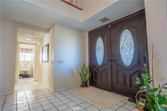 entrance foyer featuring light tile patterned flooring and a textured ceiling