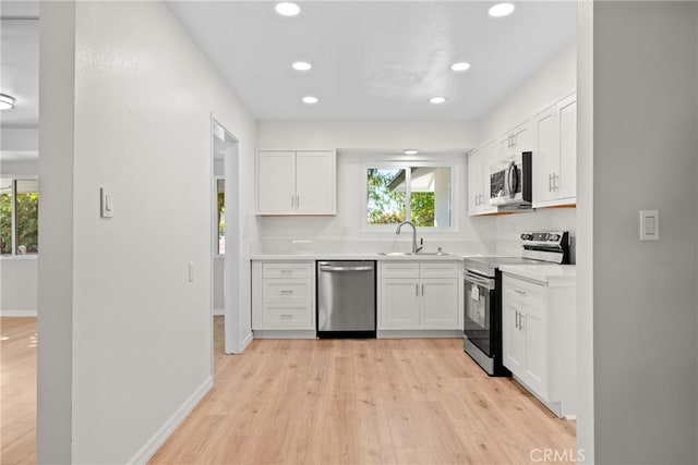 kitchen with white cabinets, appliances with stainless steel finishes, and plenty of natural light