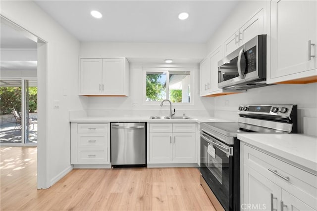 kitchen featuring white cabinets, light hardwood / wood-style floors, sink, and stainless steel appliances