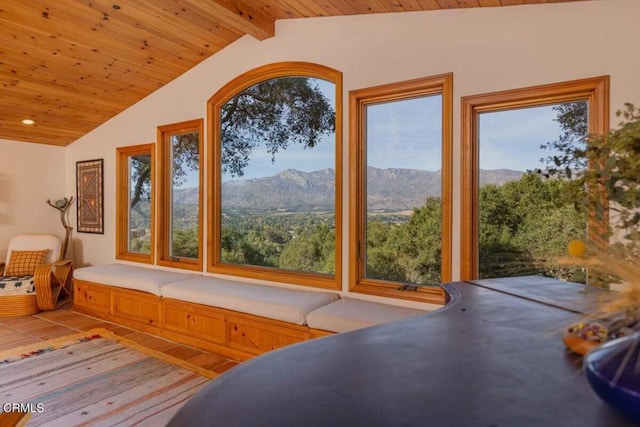 unfurnished sunroom with a mountain view, vaulted ceiling with beams, and wooden ceiling