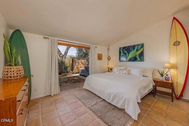 tiled bedroom with lofted ceiling and access to outside