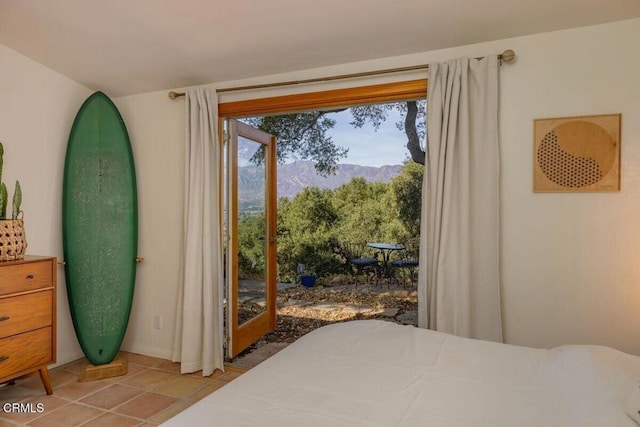 tiled bedroom with a mountain view and access to exterior