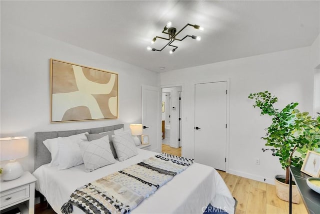 bedroom featuring a notable chandelier and light hardwood / wood-style floors