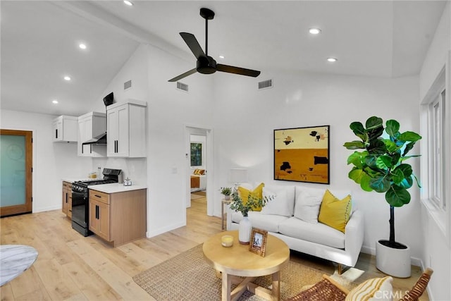 living room featuring ceiling fan, beamed ceiling, high vaulted ceiling, and light wood-type flooring