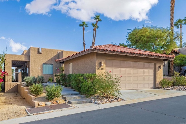 view of front of home with stucco siding, a gate, concrete driveway, a garage, and a tiled roof