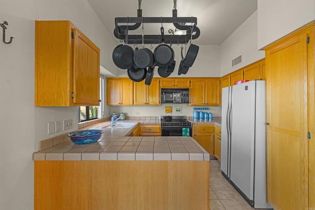 2842 Fonts Point Dr, Borrego Springs, CA 92004 - kitchen with black appliances, a peninsula, a sink, light tile patterned flooring, and tile countertops