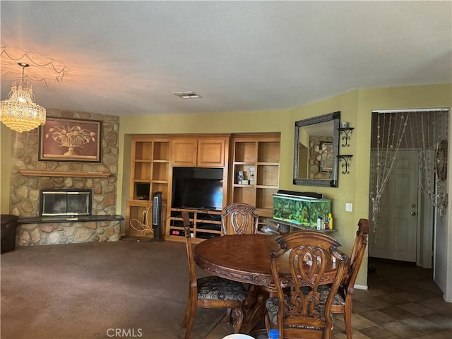 dining room featuring carpet and a stone fireplace