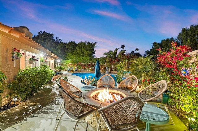 patio terrace at dusk featuring an outdoor fire pit