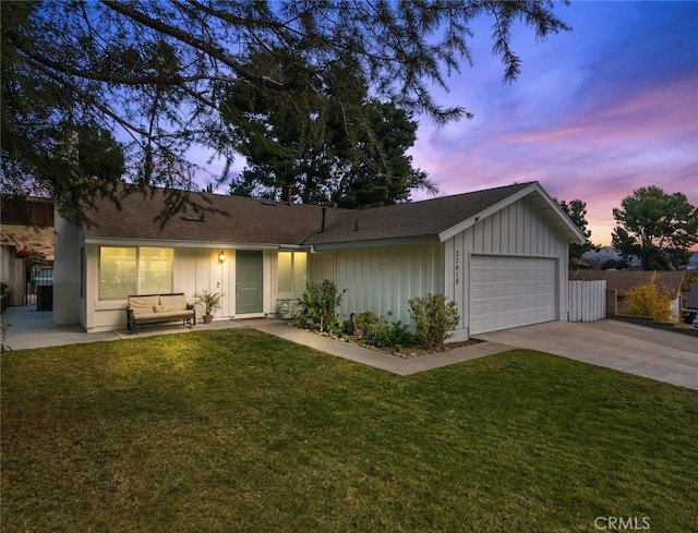 single story home featuring a garage and a yard