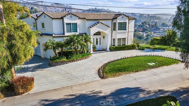 2034 Virazon Dr, La Habra Heights, CA 90631 - view of front of property featuring curved driveway, stucco siding, a tiled roof, and a garage