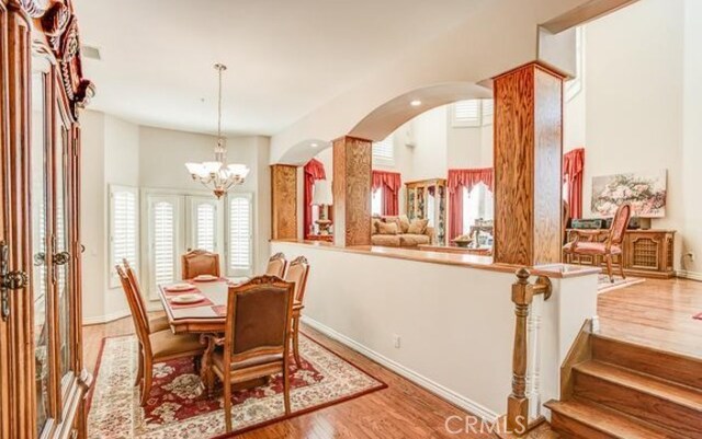 2034 Virazon Dr, La Habra Heights, CA 90631 - dining room featuring wood finished floors, a chandelier, and arched walkways