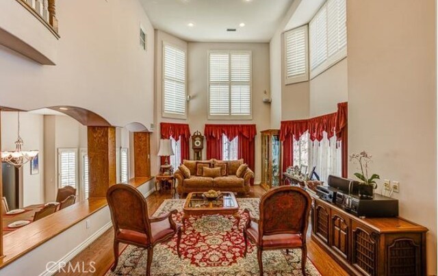 2034 Virazon Dr, La Habra Heights, CA 90631 - living area featuring a towering ceiling, wood finished floors, a chandelier, healthy amount of natural light, and arched walkways