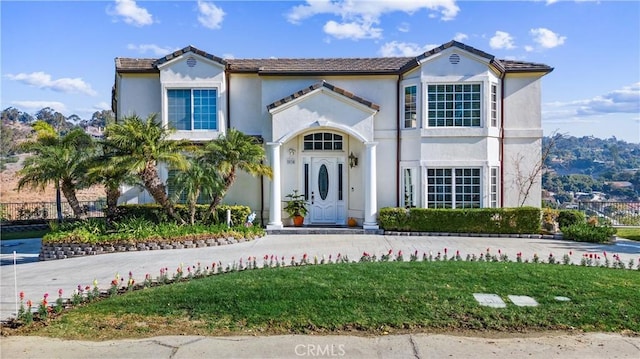 mediterranean / spanish house with a front lawn